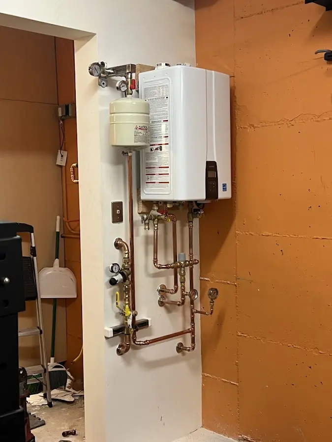 Plumbing technician inspecting water heater connections in Baltimore